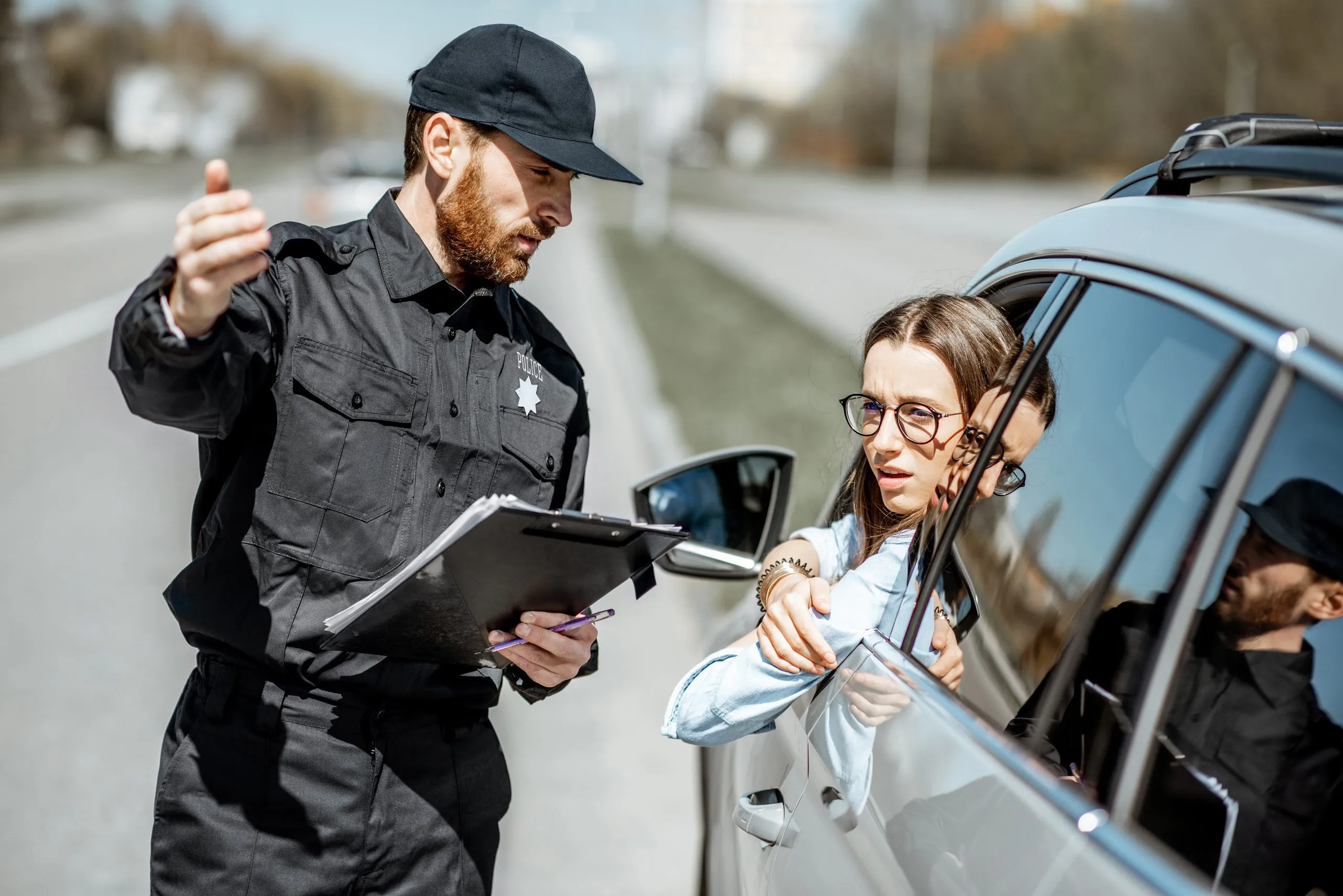Male police officer talking to female driver during a traffic stop. Our Kansas City traffic lawyers can help you keep your driving record clear.